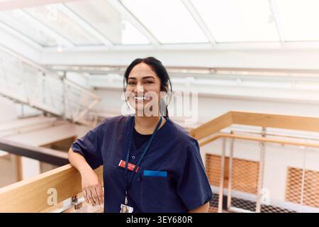 Portrait d'une femme médecin souriante posant avec confiance dans le balcon de l'hôpital Banque D'Images