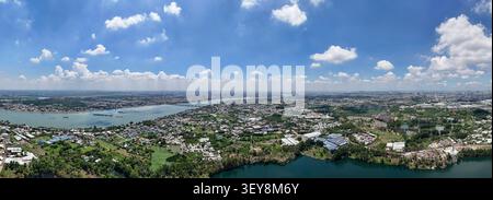 Vue panoramique aérienne haute résolution d'un vaste paysage urbain et d'une rivière sous un ciel bleu lumineux avec des nuages blancs moelleux. Banque D'Images