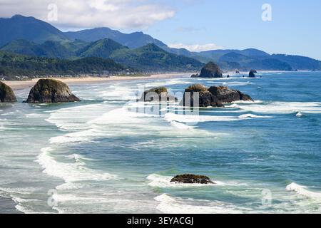 Seastacks et l'emblématique Haystack Rock dans les vagues côtières à Cannon Beach sur Orgeon Coast Banque D'Images