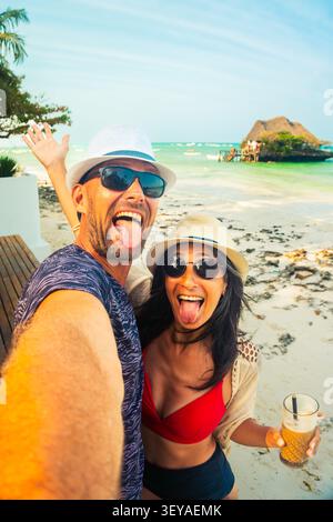 Couple ludique prenant selfie de plage drôle à Zanzibar Tanzanie, vacances tropicales, style de vie de voyage insouciant, côte de l'océan Indien, vacances joyeuses Mo Banque D'Images
