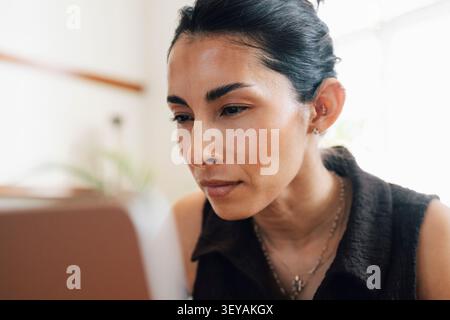 Gros plan d'une femme d'affaires concentrée regardant l'écran de son ordinateur portable tout en travaillant dans un espace de coworking Banque D'Images