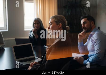 Groupe de professionnels de l'entreprise écoutant attentivement pendant la réunion Banque D'Images