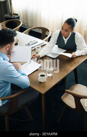 Vue en grand angle d'une conseillère financière expliquant les détails du contrat au client Banque D'Images