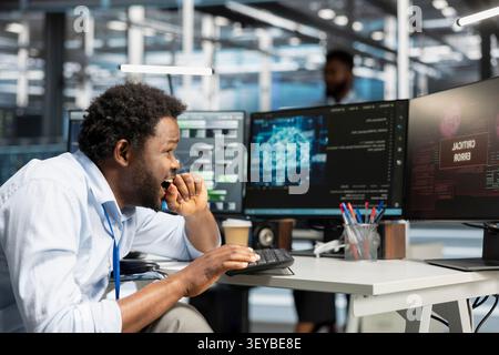 L'administrateur du centre de données utilise un ordinateur pour écrire du code pour les systèmes d'IA, travaillant avec la technologie d'IA et les systèmes haute performance. Banque D'Images