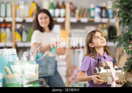 Portrait d'une fille tenant un ensemble de cadeaux dans ses mains dans le magasin de biens à la maison Banque D'Images