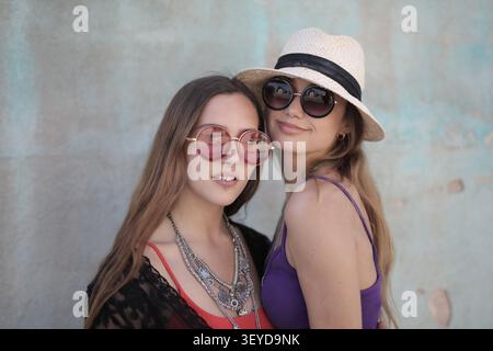 Deux jeunes femmes élégantes en lunettes de soleil posant Banque D'Images