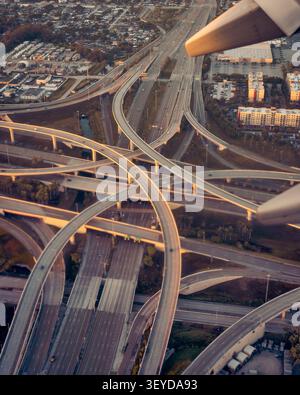 Vol au-dessus d'un échangeur routier massif au crépuscule Banque D'Images