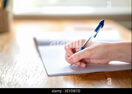 Gros plan de l'enfant écrivant ses devoirs Banque D'Images
