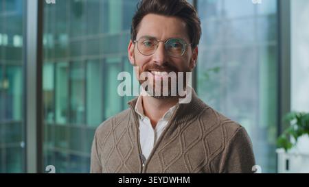 Homme d'affaires caucasien dans des lunettes regardant la caméra souriant joyeux homme d'affaires réussi exécutif masculin sourire joyeux optimiste au bureau. Adulte Banque D'Images