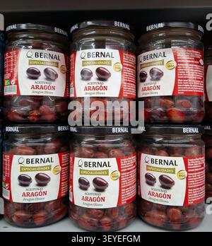 DENIA, ESPAGNE - 15 novembre 2025. Une vue rapprochée de bocaux remplis d'olives rouges en vente sur les étagères des supermarchés en Espagne. Cet écran met en surbrillance qua Banque D'Images