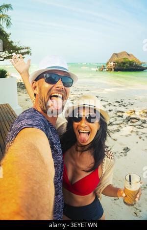 Couple ludique prenant selfie de plage drôle à Zanzibar Tanzanie, vacances tropicales, style de vie de voyage insouciant, côte de l'océan Indien, vacances joyeuses Mo Banque D'Images