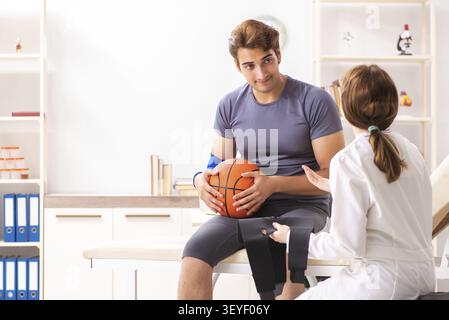 Beau joueur de basket-ball féminin en visite médecin traumatologist Banque D'Images