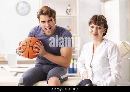 Beau joueur de basket-ball féminin en visite médecin traumatologist Banque D'Images