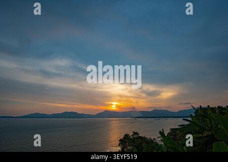 Les nuages moelleux obscurcissent le magnifique ciel alors que le soleil se couche sur la mer. fond de nuages doux et moelleux. incroyable les nuages doux ont déplacé les formes dedans Banque D'Images