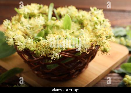 Linden arbre fleurit dans le panier sur la table en bois, gros plan Banque D'Images