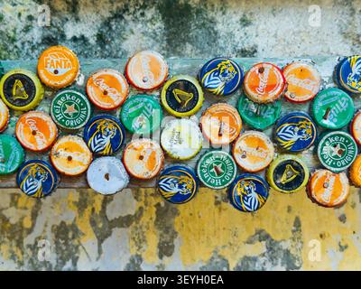 Collection de bouchons de bouteilles en métal de marque, y compris Coca-Cola, Heineken & Tiger cloués sur une planche de bois Banque D'Images