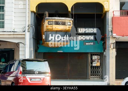 Upside Down World attraction à Ipoh Malaisie avec une cabine Mercedes-Benz jaune inversée et une Nissan Serena garée devant Banque D'Images