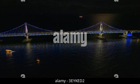 Pont de Gwangan enjambant les eaux calmes de l'océan, présentant un éclairage dynamique et une architecture moderne après la tombée de la nuit à busan, en corée du Sud Banque D'Images