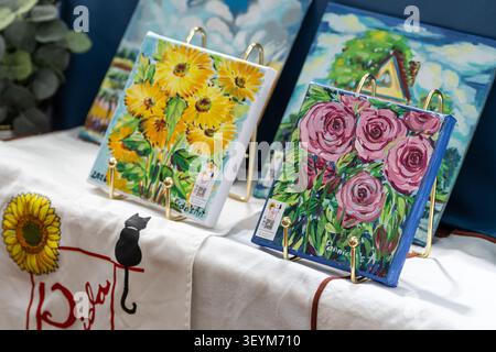 Chiang mai, Thaïlande - 27 mai 2026 : peintures acryliques de tournesols et de roses par Pannida's Art exposées sur des chevalets en or Banque D'Images