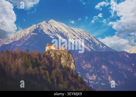 Vue sur le château de Bled contre les montagnes enneigées du lac de Bled Banque D'Images