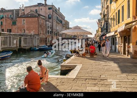 Les gens se relaxent et dînent près d'un canal pittoresque à Venise, Italie Banque D'Images