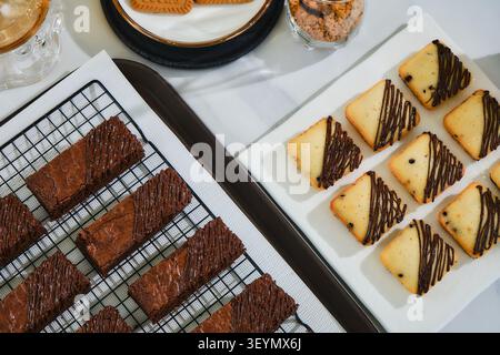 Une variété de pâtisseries françaises, disposées sur des assiettes de service, sont préparées pour la vente dans une pâtisserie. Banque D'Images