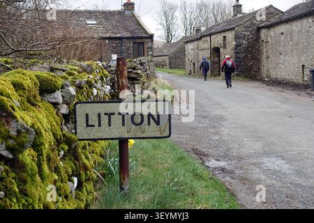 Deux hommes âgés (randonneurs) marchant à travers le hameau agricole de Litton à Littondale, Yorkshire Dales National Park, Yorkshire, Angleterre, Royaume-Uni Banque D'Images