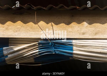 Enchaîné un store en bambou bleu et blanc sous une poutre en bois. Asie du Sud-est Banque D'Images