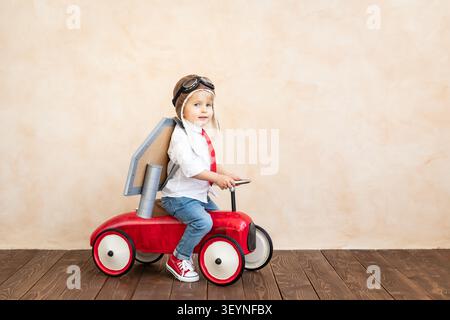 Drôle d'enfant avec jouet jet pack.Enfant heureux jouant à la maison.Concept de technologie de réussite, d'imagination et d'innovation Banque D'Images