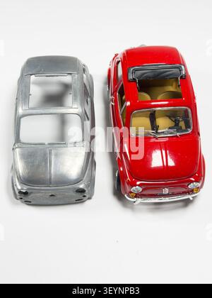 Vue de dessus d'un modèle à l'échelle Fiat 500 rouge et d'un corps en métal non peint sur fond blanc Banque D'Images