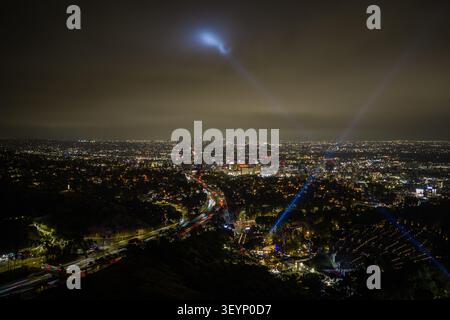 Vue aérienne nocturne de Los Angeles avec des routes lumineuses et Hollywood Bowl la nuit. Quartier hollywoodien dense, gratte-ciel lointain, sombre Banque D'Images
