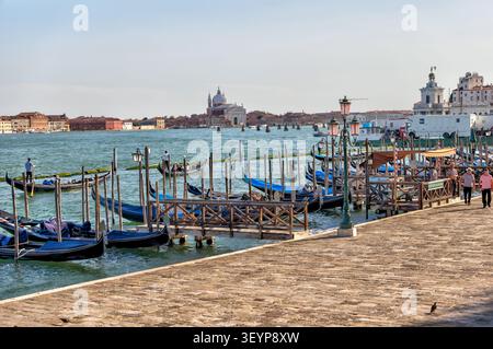 Gondoles amarrées le long de la Riva degli Schiavoni surplombant San Giorgio Maggiore à Venise, Italie. Banque D'Images