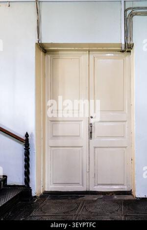 fermé grande double - porte en bois peint blanc de feuille dans le bâtiment Banque D'Images