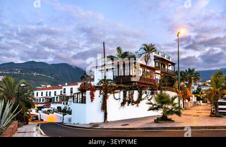 Bâtiments blancs traditionnels avec balcons en bois et palmiers au crépuscule à Puerto de la Cruz, Tenerife, Îles Canaries, Espagne. Banque D'Images