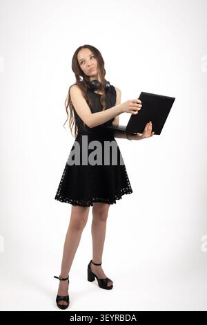 Jeune modèle féminin tenant un ordinateur portable décontracté dans une photo professionnelle s... Banque D'Images