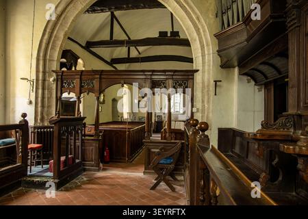 Vue intérieure d'une ancienne église paroissiale présentant un jubé en bois, des poutres en bois, des arcs en pierre et des bancs traditionnels Église Saint-Nicolas Leckford Banque D'Images
