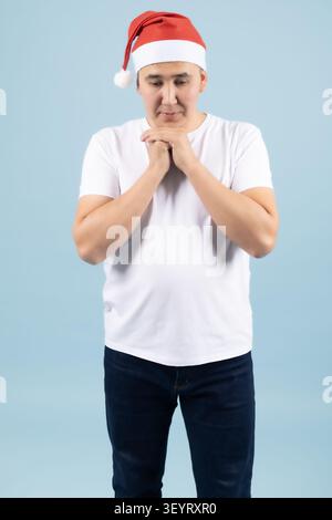 Jeune homme souriant avec les mains sous le menton heureusement Banque D'Images
