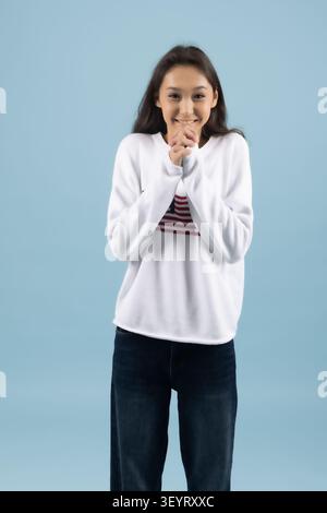 Jeune femme posant l'air surpris en studio Banque D'Images