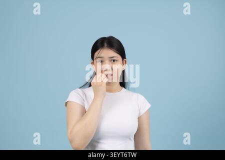 Jeune femme réfléchie regardant loin dans le studio dans un studio photo professionnel ... Banque D'Images