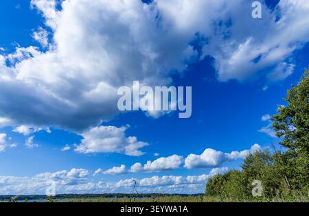 Paysage nuageux d'été avec des nuages cumulus au-dessus de terres agricoles ouvertes près du village historique d'artistes de Ferch au lac Schwielowsee, Brandebourg, Allemagne. Banque D'Images
