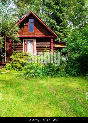 pelouse verte devant la maison rustique en bois en rondins le jour ensoleillé d'été Banque D'Images