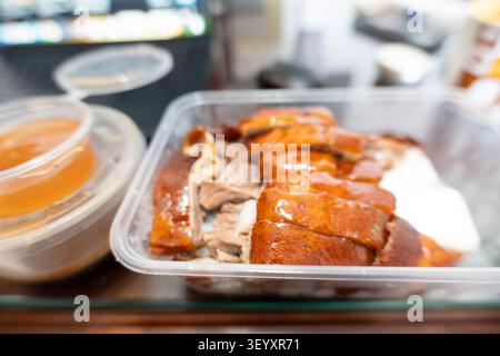 Canard rôti de Pékin (Peking Duck) servi dans un contenant à emporter en plastique avec sauce aux haricots sucrée Banque D'Images