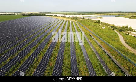 Grande centrale solaire générant de l'énergie propre à partir du soleil dans un vaste paysage rural près d'une zone de déchets industriels Banque D'Images