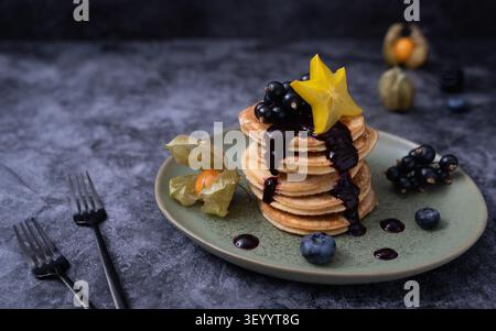 Petit déjeuner composé de crêpes moelleuses avec fruits frais et éclairage photographique spectaculaire Banque D'Images