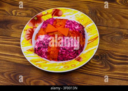 Salade russe traditionnelle 'hareng sous un manteau de fourrure' (shuba) sur table en bois. Salade faite dans une forme de boîte cadeau Banque D'Images
