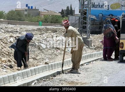 QUETTA, PAKISTAN - 05-Jul-2026 : les travailleurs sont activement engagés dans la construction de routes sur Samangali Road à Quetta à partir du dimanche 5 juillet 2026. Le projet, qui comprend une bordure de béton nouvellement construite, signale le développement continu des infrastructures dans la région. Cet effort de construction est essentiel pour améliorer les transports et la connectivité à Quetta, contribuant ainsi à la croissance économique et à l’accessibilité. Le site, caractérisé par un environnement aride et des débris dispersés, met en évidence les défis auxquels de tels projets sont confrontés. Ces développements sont cruciaux pour améliorer les infrastructures locales et soutenir l'urbanisme Banque D'Images
