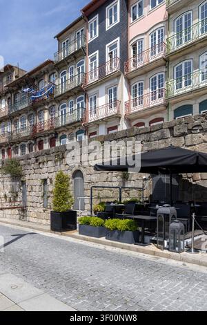 Porto, Portugal - 12 mai 2026 : charmante rue historique dans le quartier de Ribeira près du fleuve Douro. Touristes se relaxant dans les cafés en plein air Banque D'Images