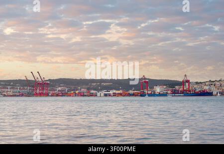 LISBONNE, PORTUGAL - nov 09, 2025 : cargo commercial est amarré à un port terminal à conteneurs à Lisbonne, Portugal, vu à travers le Tage Riv bleu Banque D'Images