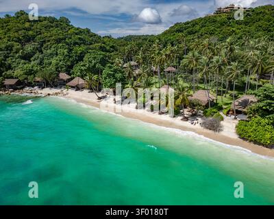 Vue aérienne d'une plage tropicale isolée sur Koh Tao, Thaïlande, avec de l'eau turquoise, du sable blanc, des palmiers et des collines luxuriantes, capturée en été lumineux Banque D'Images