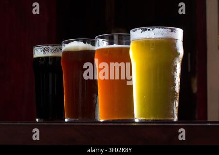 Dégustation de bières artisanales avec quatre styles de bière différents dans des verres à pinte Banque D'Images